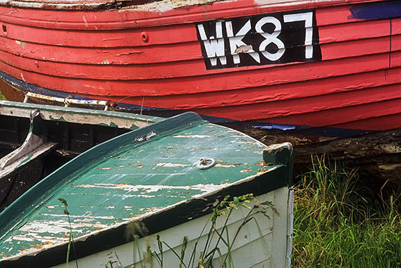 SCO: Highland Region, Caithness District, Northern Coast, Thurso, Small wooden boats, brightly colored, in a grassy field in town [Ask for #246.818.]