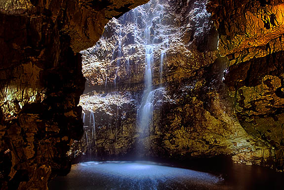 SCO: Highland Region, Sutherland District, Northern Coast, Durness, Smoo Cave, Waterfall inside Smoo Cave, formed as stream flows into cave through a hole in roof. [Ask for #246.857.]