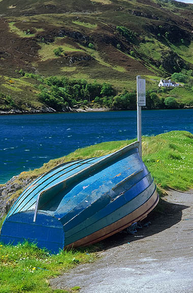 SCO: Highland Region, Sutherland District, Northern Coast, Durness, Kyle of Durness, Keoldale Pier, the location of the passenger ferry to Cape Wrath; wood boat leaning against sign. [Ask for #246.864.]