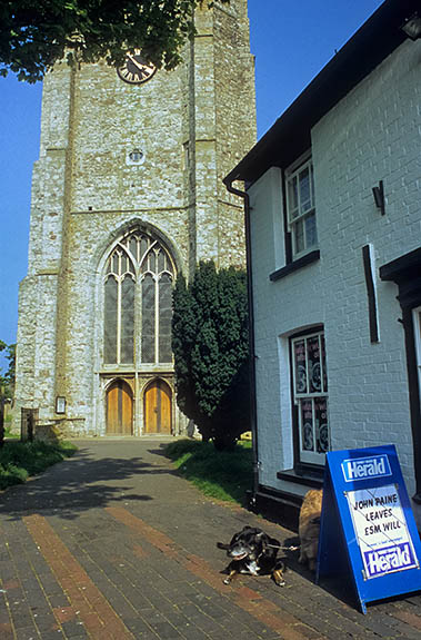 ENG: South East Region, Kent, Romney Marsh, The South Marsh, Lydd, Village grocer in front of the village church with its 130' tower, known as "The Cathedral of Romney Marsh" [Ask for #256.475.]