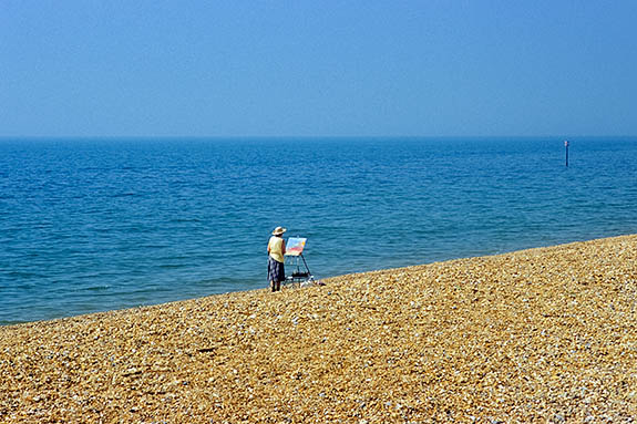 ENG: South East Region, Kent, Romney Marsh, Romney Marsh Beaches, Woman artist on shingle beach painting [Ask for #256.501.]