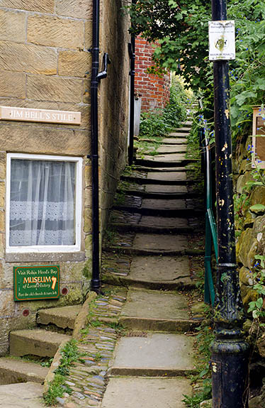 ENG: Yorkshire & Humberside Region, North Yorkshire, North Yorkshire Coast, Sea Cliffs, Robin Hood's Bay, Village lane climbs cliff with steps, lined by stone walls and cottages [Ask for #270.067.]